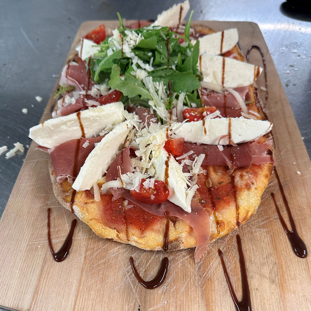 Pinsa mit Mozzarella, Prosciutto crudo und rucola